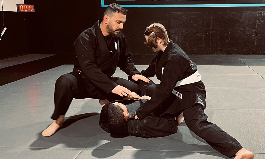 Professor teaching two teens Jiu Jitsu